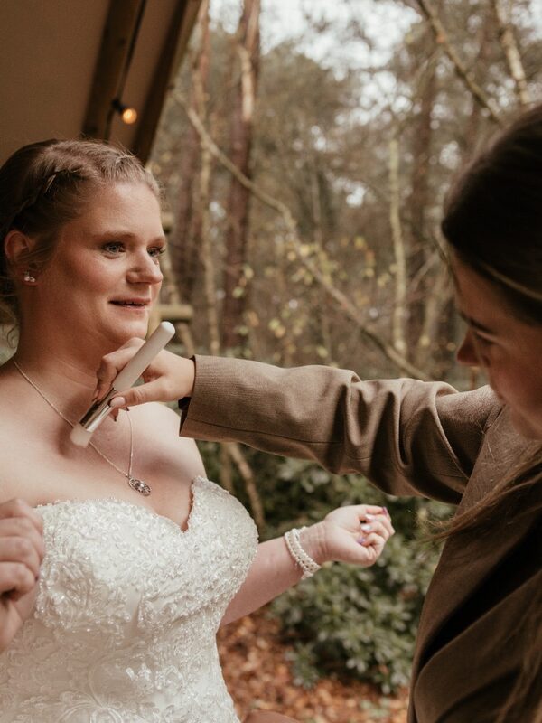 Danique speldt buiten het haar van een bruid vast, vlak voor de ceremonie