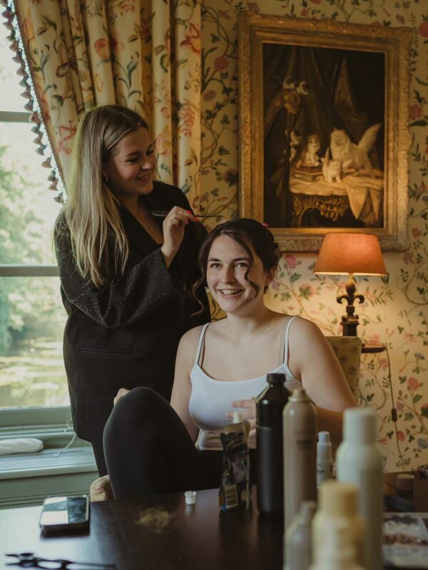 Danique en een bruid kijken samen in de spiegel in een klassieke kamer