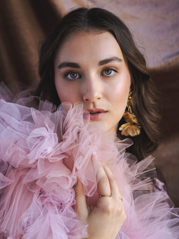 Model met roze tule en lange donkere golven