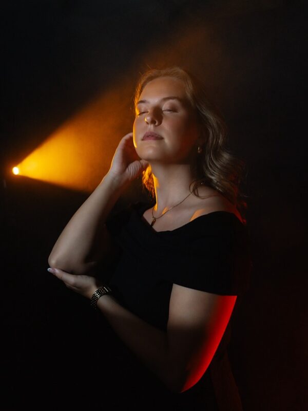 Model in warm rood en geel licht