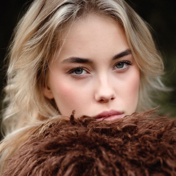 Blond model in bruine bontjas, close-up
